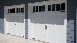 A pair of white garage doors with garage door window inserts